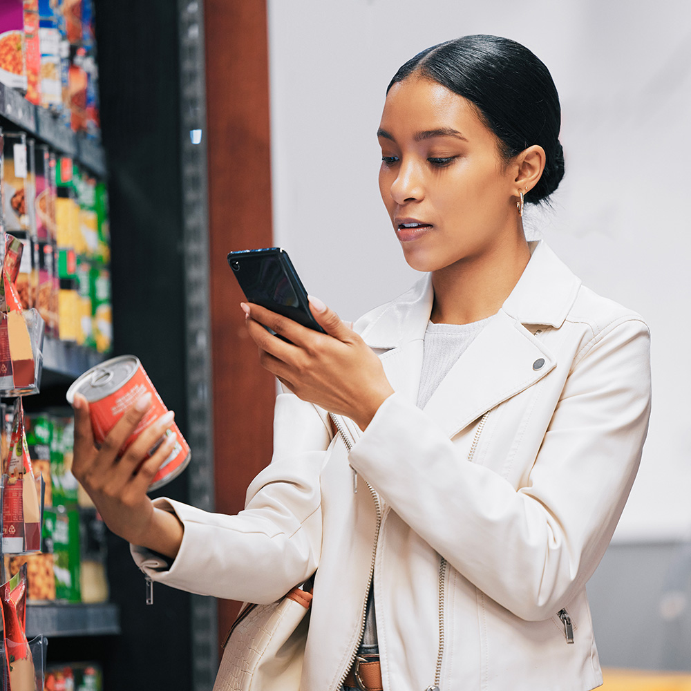 Businessman examining a drink bottle in a grocery aisle.